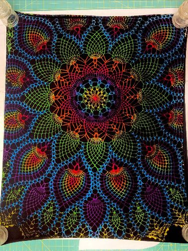 a black blanket with a large rainbow mandala.